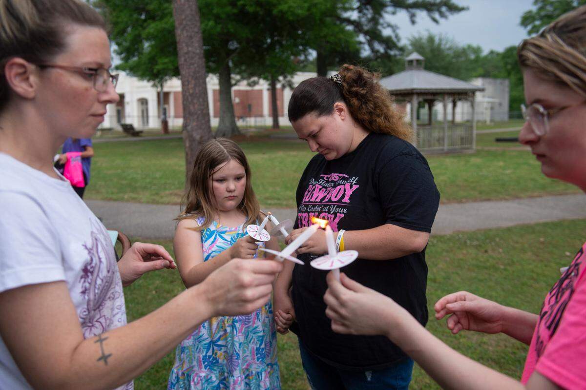 Community members light candles during a candlelight vigil in remembrance of Gracelynn Vick at Saucier Park on Tuesday, April 22, 2025.