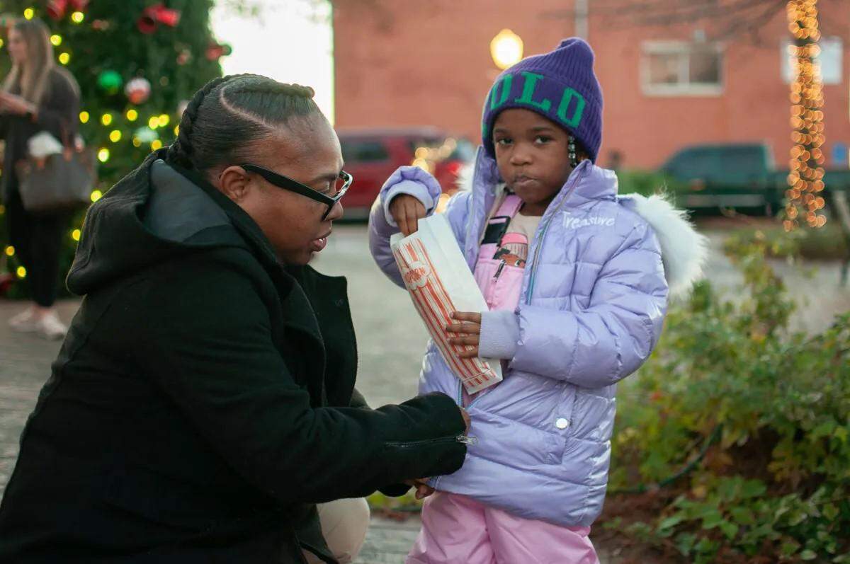 Tiffany Ceasar zips up 5-year-old daughter Treasure Dulaney’s coat at the Second Annual Christmas Tree Lighting in Belzoni, on Dec. 5, 2023.
