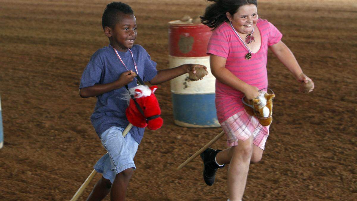 TIM ISBELL/SUN HERALD/FILETayrell Dixon and Montana Ladner are neck and neck during a broom horse race at second annual Horsing Around at the Harrison County Fairgrounds. The fairgrounds will be the venue for the Harrison County Fair in September.