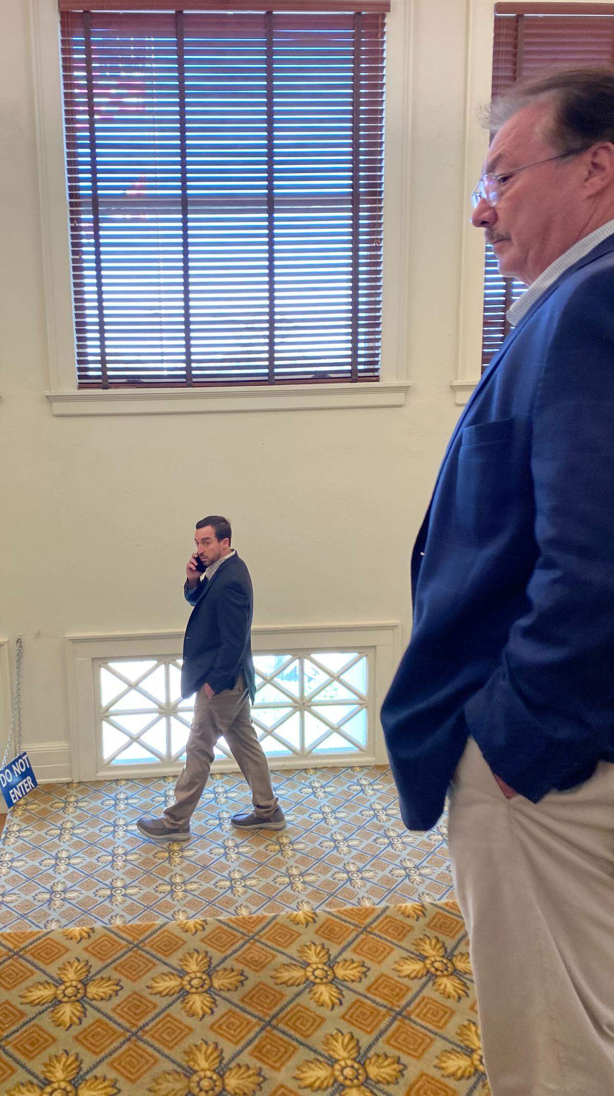 Alan Moran speaks on a phone Wednesday in front of his father, former state Sen. Philip Moran.