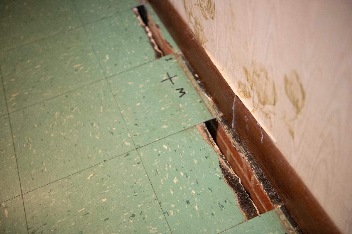 Broken floor tiles inside Milton Grishman’s real estate office on Wednesday, Feb. 9, 2022. The tiles are breaking and separating where the floor meets the wall due to the shifting of the building following Oscar Renda’s road work.