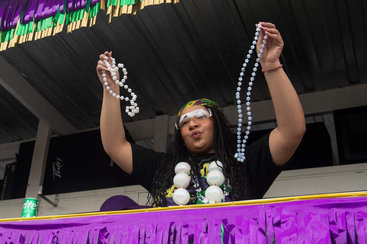 A float rider throws beads from a float during the Krewe of Gemini parade in downtown Gulfport on Saturday, Feb. 10, 2024.