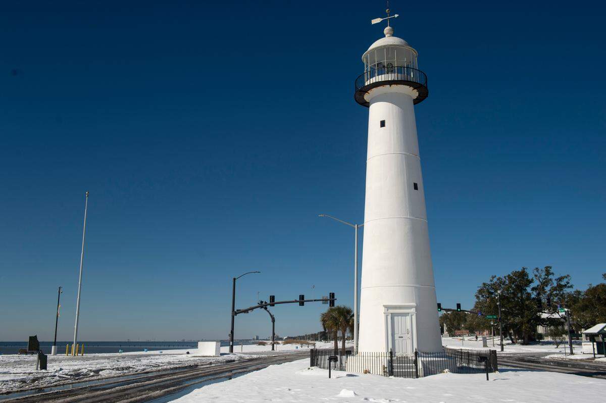The lighthouse in Biloxi stands surrounded by snow Wednesday, Jan. 22, 2025.