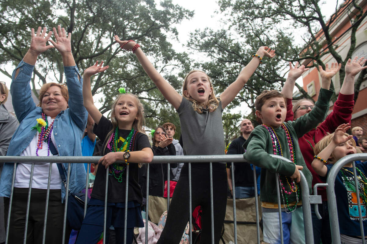 Parade attendees cheer for beads during The Ocean Springs Elks Carnival Parade in downtown Ocean Springs on Saturday, Jan. 27, 2024.