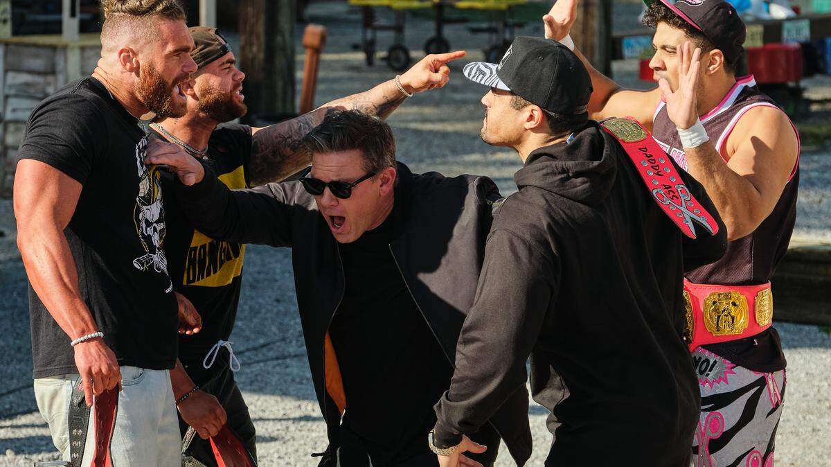 Great Food Truck Race host Tyler Florence separates All Elite Wrestling tag teams The Gunns (left) and The Acclaimed during the Food Network reality show’s visit to Ocean Springs.