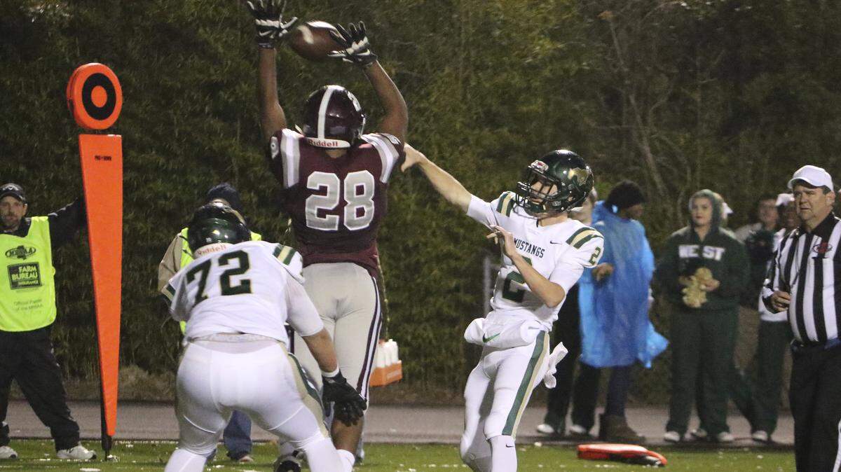 West Jones quarterback Alan Follis gets off a pass as Picayune’s Kaleb Hart (28) defends on Friday at Picayune.