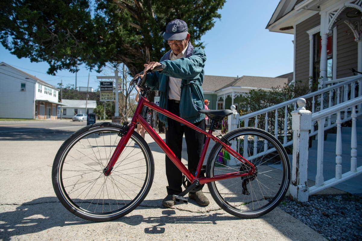 Sinh Nguyen, 76, inspects his new bike at Biloxi Bicycle Works on Wednesday, Feb. 23, 2022. College student Kevin Tran raised money for the bike for Nguyen, who relies on a bike since his vision prohibits him from driving, after his old bike was stolen.