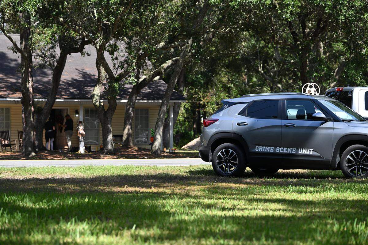 Investigators work a suspected homicide Thursday at a house on Main Street in the St. Andrews community of Jackson County.