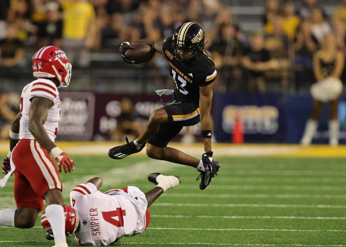 Southern Miss wide receiver Dannis Jackson (13) leaps over Louisiana safety Tyree Skipper (4) Saturday, Oct. 5, 2024, during the Golden Eagles’ loss in Hattiesburg.