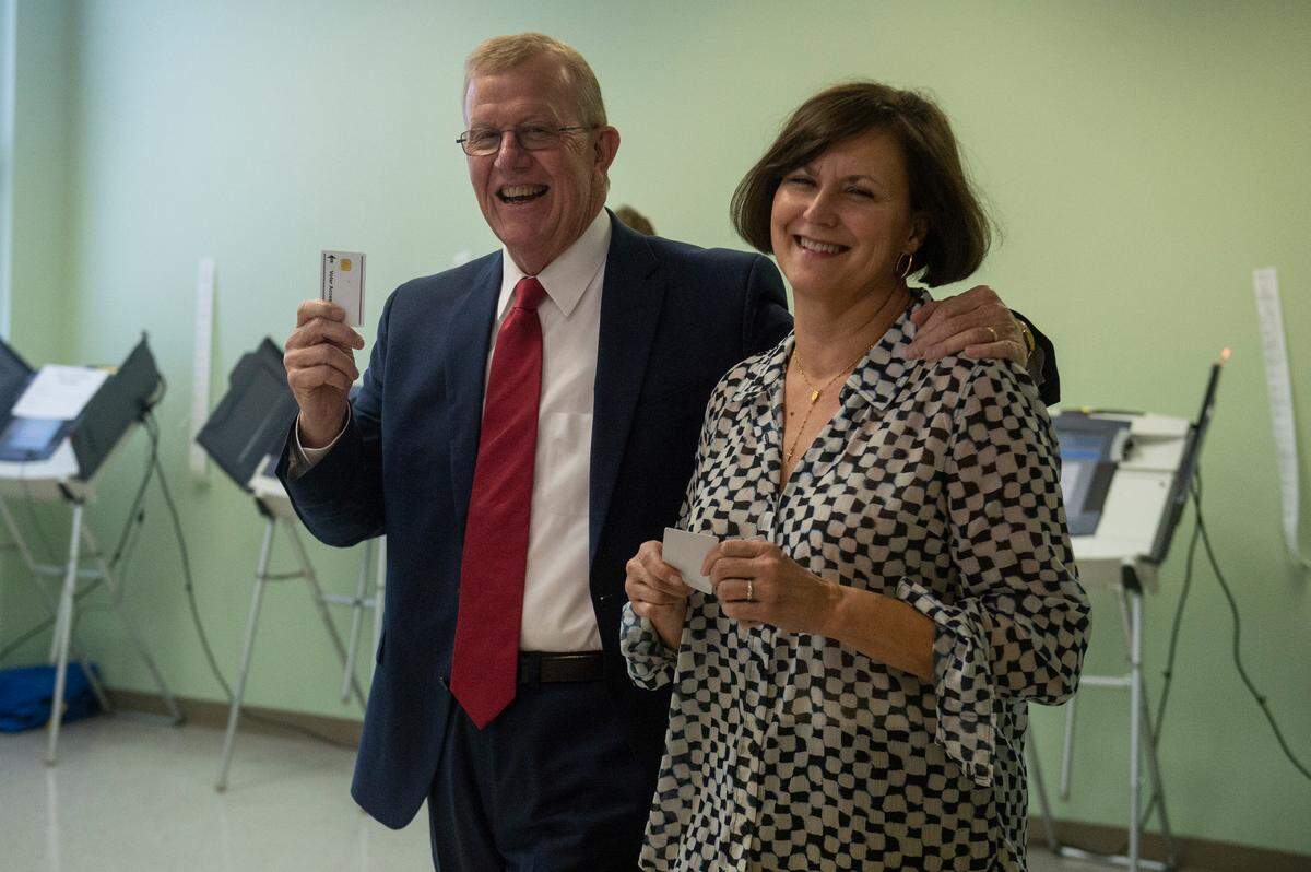 Jackson County Sheriff Mike Ezell, the Republican candidate for Mississippi’s 4th Congressional District, and his wife Suzette hold up voter access card for electronic voting machines after voting at First Presbyterian Church in Pascagoula on Tuesday, Nov. 8, 2022.