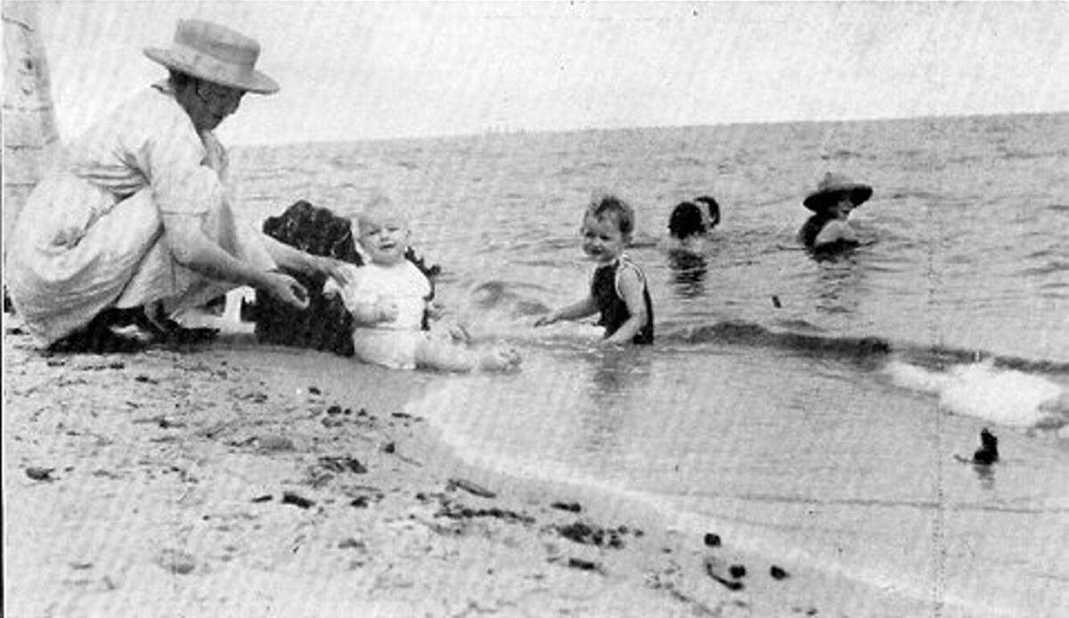 This unidentified mother and children enjoy Independence Day at the beach in Gulfport in a flashback.