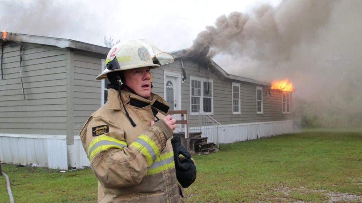 PAT SULLIVAN/HARRISON COUNTY FIRE SERVICES 
 A firefighter stands outside a mobile home on Dan Walker Road as the blaze destroyed a mobile home believed to be set afire intentionally.