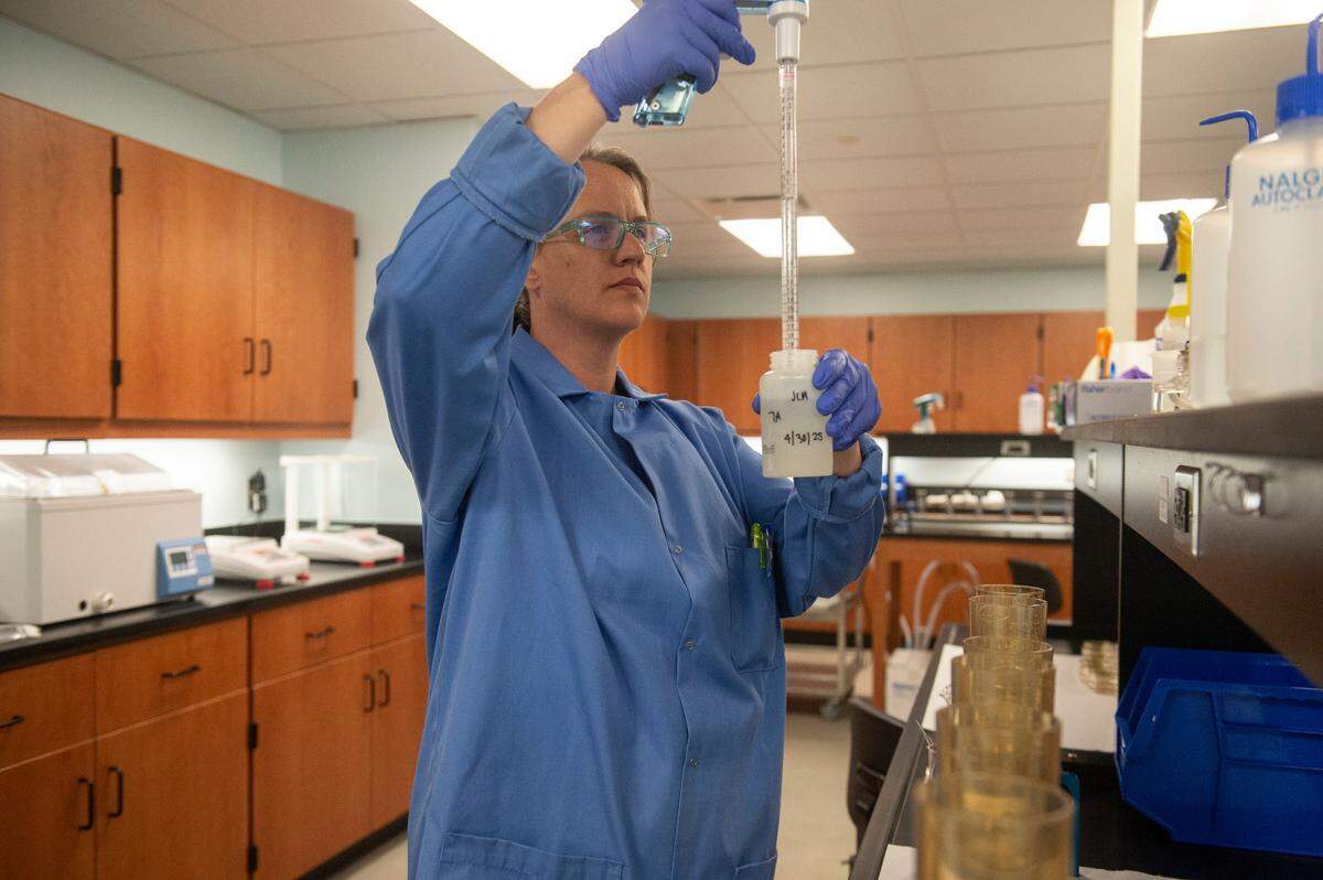 Kate Doering, an environmental biologist with the Mississippi Department of Environmental Quality, measures milliliters of water samples collected from beaches before placing the samples through a filter on Wednesday, April 30, 2025.