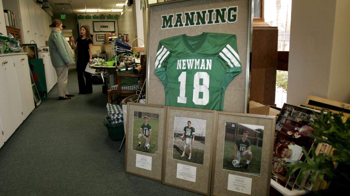 A framed jersey and photos of the Manning brothers sit in an office in Isidore Newman School in New Orleans on Friday, January 25, 2008. All three brothers, Cooper, Peyton and Eli, wore number 18 while playing football at Newman. (AP Photo/Pat Semansky)