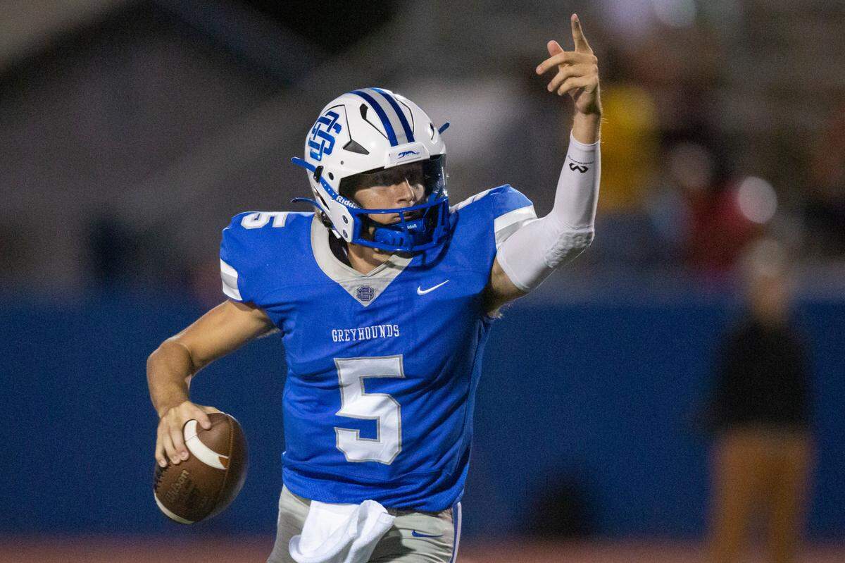 Ocean Springs quarterback Bray Hubbard signals to his teammates as he runs the ball down the field during a Jamboree game against Gautier at Greyhound Stadium in Ocean Springs on Friday, Aug. 19, 2022.