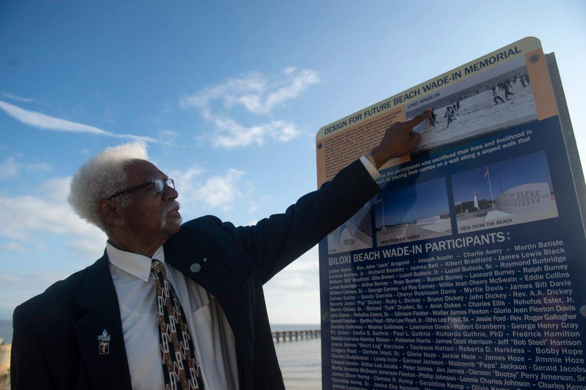 Clemon Perry Jimerson Sr., who participated in the Biloxi Wade-ins when he was 14, points out participants in a photo of Bloody Sunday that Jimerson himself is seen in on a temporary sign honoring the Wade-Ins at Biloxi Beach on Thursday, Nov. 7, 2024. A new memorial will eventually stand on Biloxi Beach honoring all the participants.