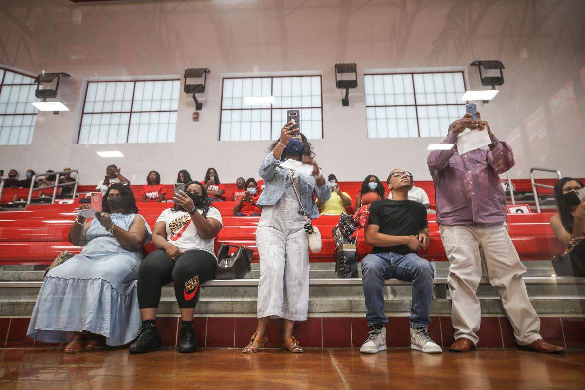 Family stands to take pictures of their graduate as they crossed the stage.