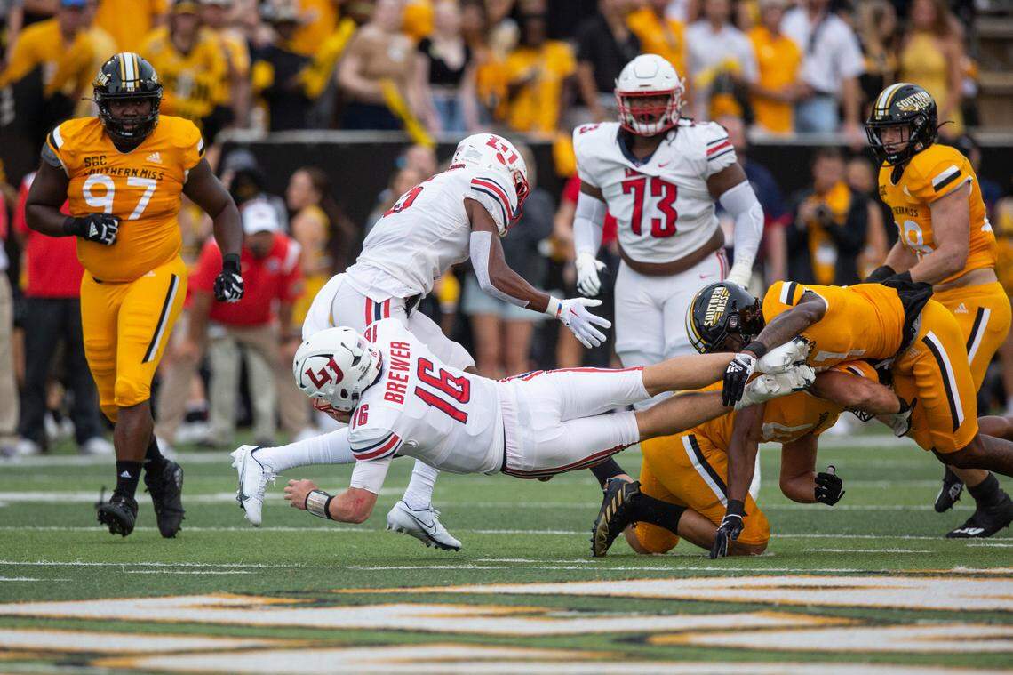 Southern Mississippi defense tackles Liberty quarterback Charlie Brewer (16) during a NCAA college football game in Hattiesburg, Miss., Saturday, Sept. 3, 2022. Southern Mississippi lost 29-27