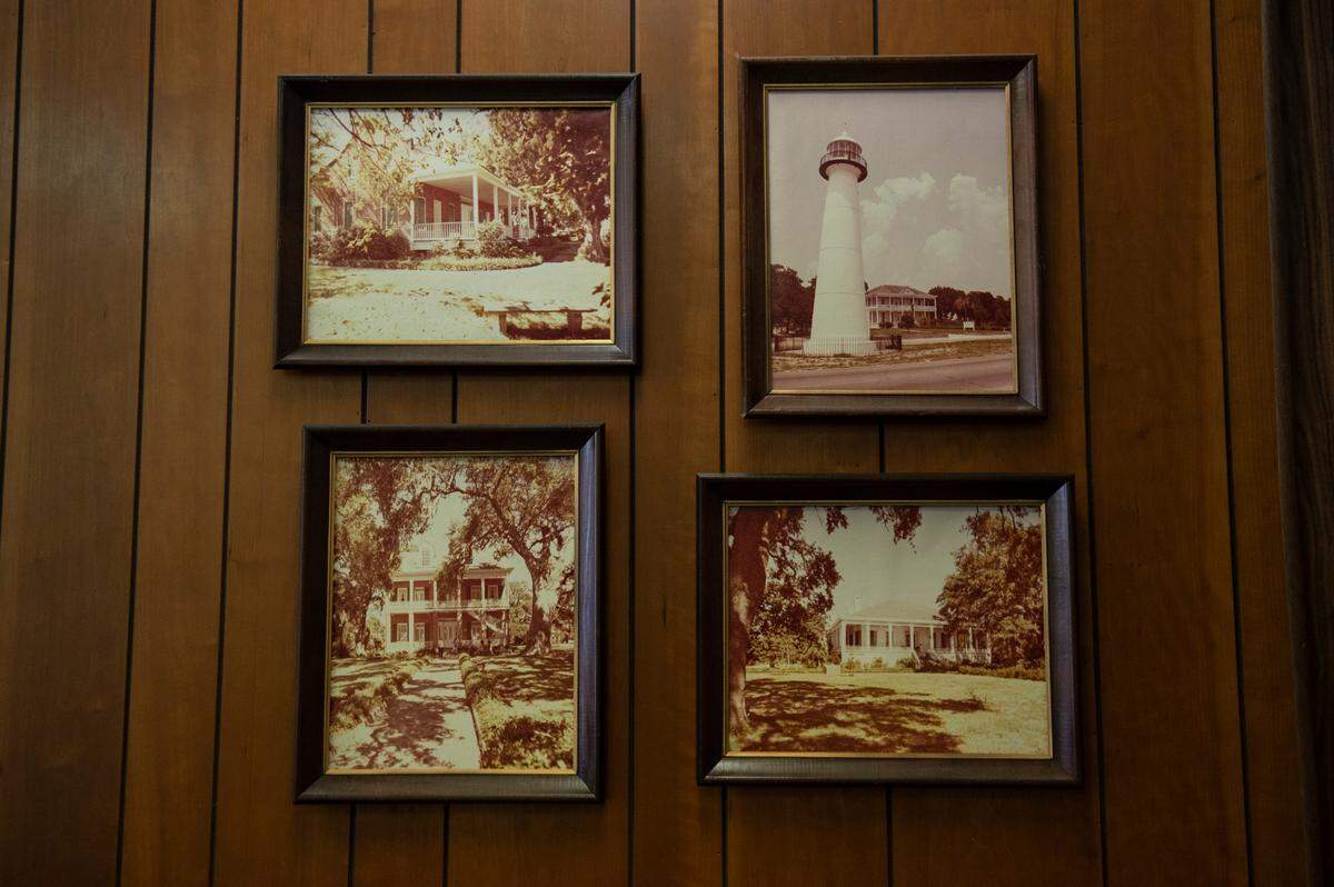Photos of Biloxi landmarks, some of which were lost in Katrina, taken by Milton Grishman on display at his real estate office on Wednesday, Feb. 9, 2022.
