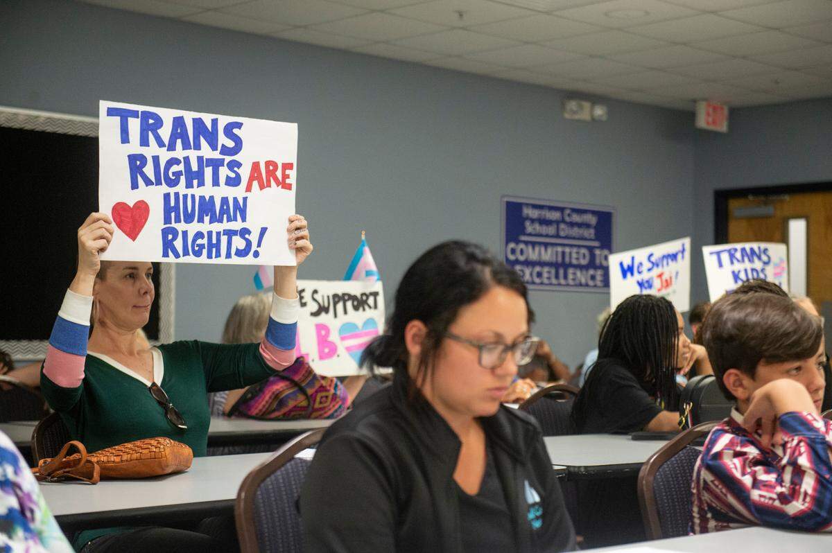 Mississippi Rising Coalition President Lea Campbell and other members of the Mississippi Rising Coalition hold posters in support of L.B., a transgender student who didn’t walk in her graduation because of the dress code, and other students who were unable to walk to due the school’s dress code during a Harrison County School Board meeting at the Central Office in Gulfport on Monday, June 5, 2023.