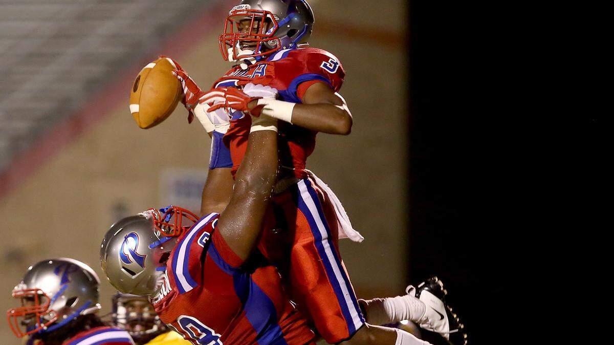 AMANDA McCOY/SUN HERALD 
 Pascagoula's James Jackson lifts teammate Cartreal Davison into the air after Davison scored a touchdown against Hattiesburg on Friday, October 16, 2015, at Pascagoula High.