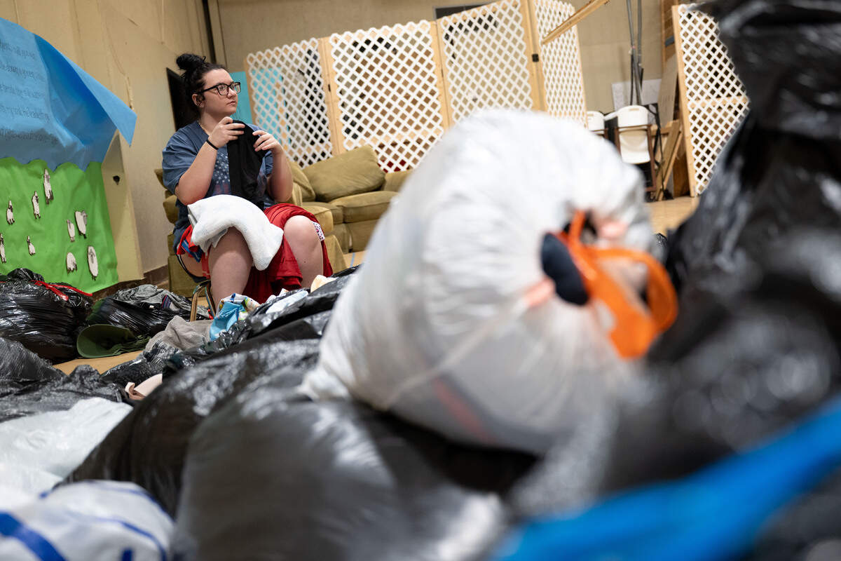 Kerrigan O’Neal folds clothes from dozens of trash bags full of donated clothes June 24 for those in need at the LaVay Crawley Memorial Life Center in Wiggins.