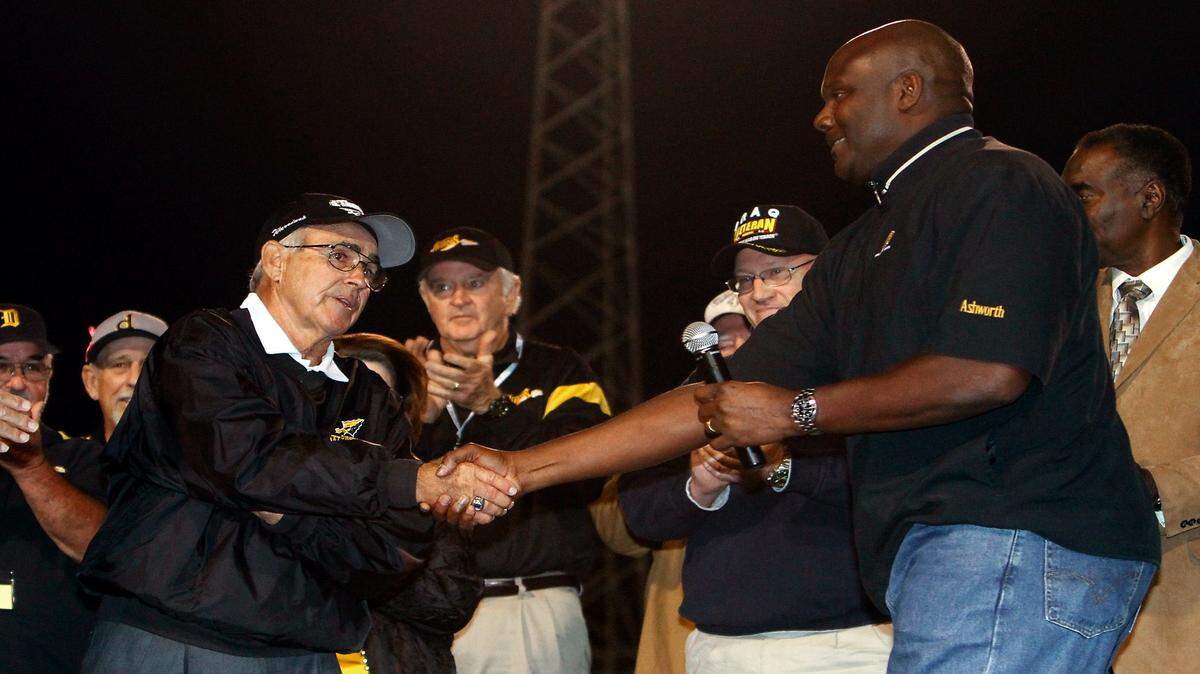 AMANDA McCOY/SUN HERALD 
 
 Reggie Collier, right, congratulates his former high school football coach Buddy Singleton, left, during a ceremony to name the field at Warrior Stadium "Buddy Singleton Field" on Friday, October 21 2011. Many of Singleton's former players were on hand for the occasion.