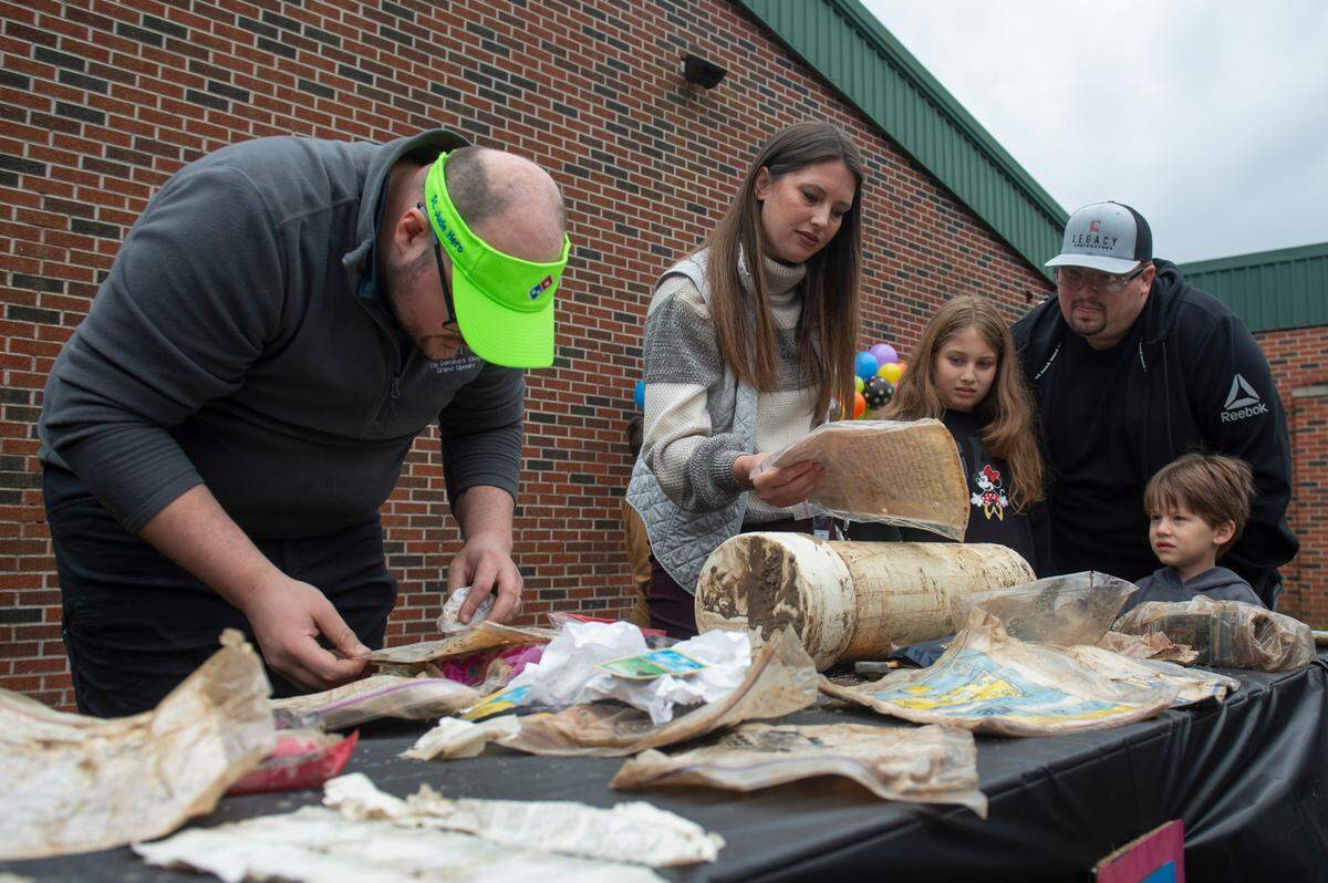 Former students at W. J. Quarles Elementary in Long Beach and their families look through items from a time capsule opened on Friday, Dec. 13, 2024, that they and their classmates buried in 1999.