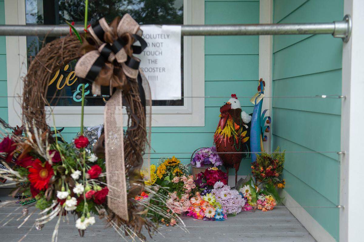 Flowers and gifts in honor of Carl the rooster sit outside of Twisted Anchor in Ocean Springs on Monday, May 2, 2022. Carl, a local celebrity and community pet, loved to roost on the porch of Twisted Anchor before he was killed last week.