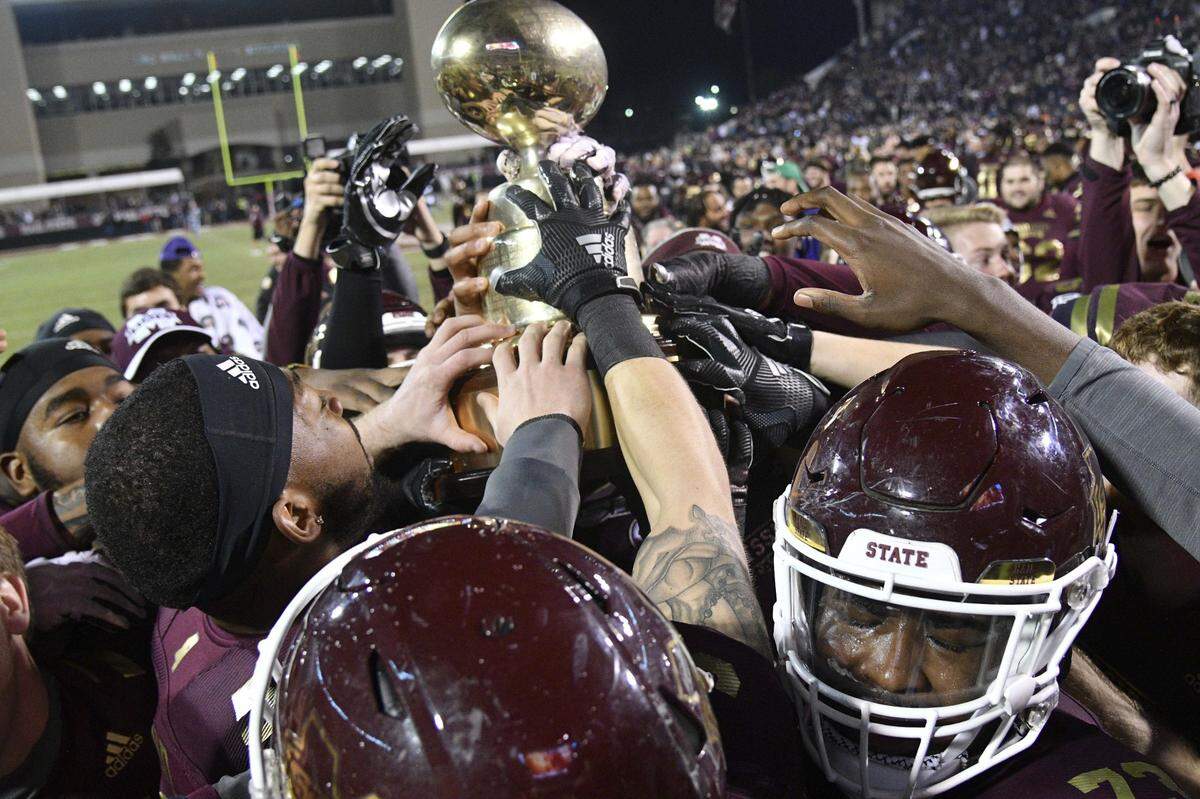 Mississippi State Bulldogs players react with the Egg Bowl Trophy after defeating the Mississippi Rebels at Davis Wade Stadium. Mandatory Credit: Matt Bush-USA TODAY Sports