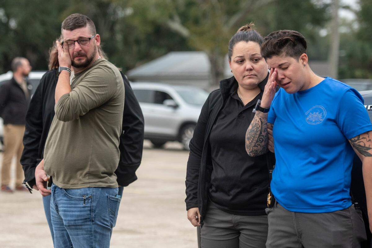 Onlookers and members of law enforcement tear up as a procession of law enforcement officers drives down Main Street in Bay St. Louis escorting the body of Sgt. Steven Robin as it is taken to Edmond Fahey funeral home on Wednesday, Dec. 14, 2022. Robin was killed along with another officer while on duty.