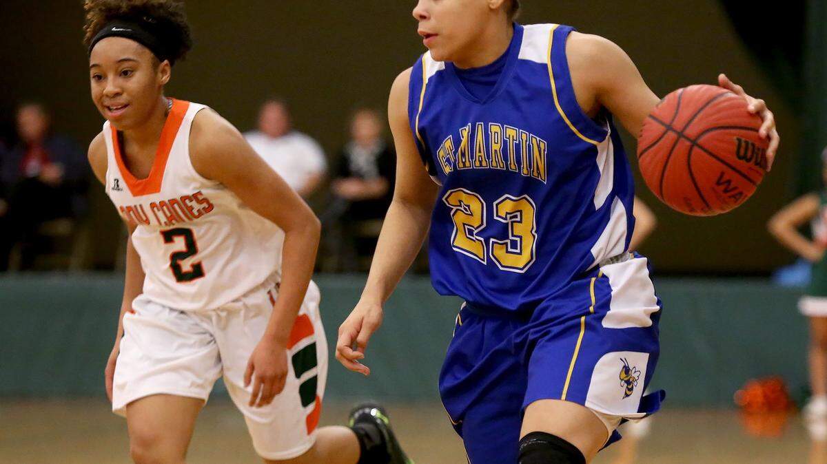 AMANDA McCOY/SUN HERALD 
 St. Martin's Deona Morgan dribbles the ball while followed by West Harrison's Deseree Moore on Friday, February 5, 2016, at West Harrison High.