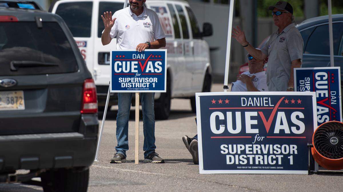 Dan Cuevas, a candidate for District Supervisor 1 in Harrison County, waves to voters arriving at a polling location at D’Iberville Civic Center in D’Iberville during the Mississippi Primary Election on Tuesday, Aug. 8, 2023.