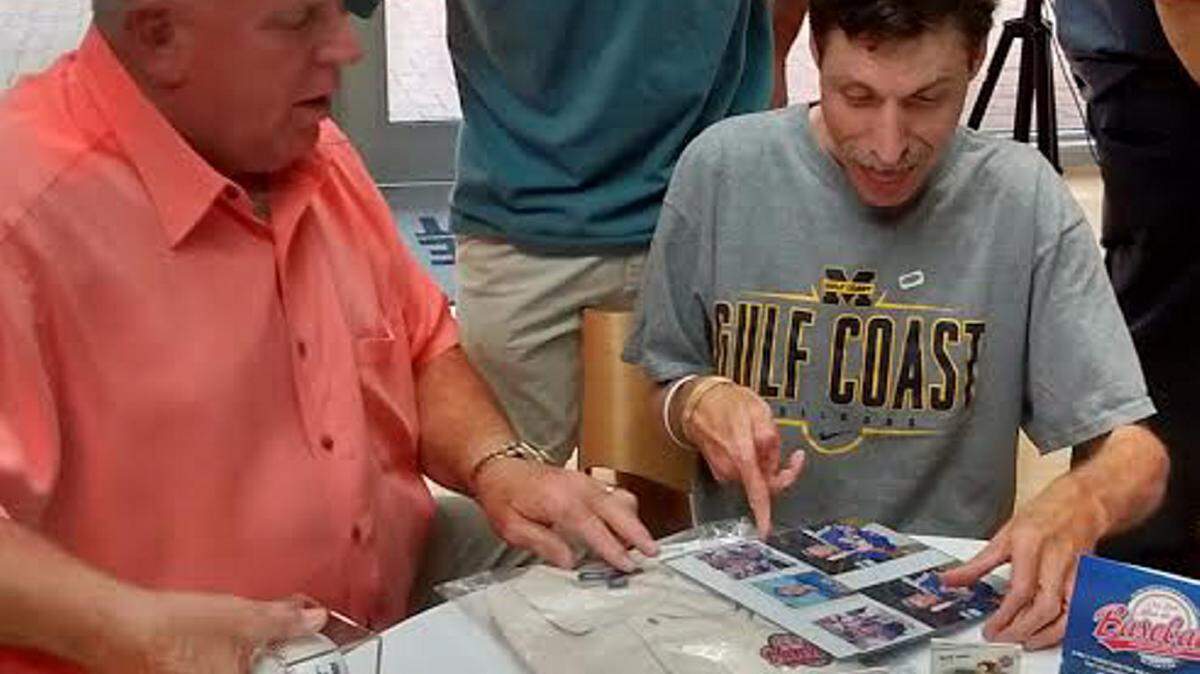 VETO ROLEY/SPECIAL TO THE SUN HERALD 
 Barry Lyons, left, signed several photos and baseball cards for Buddy Mills. Dylan Mills-Derouen, Mills' nephew, looks on.