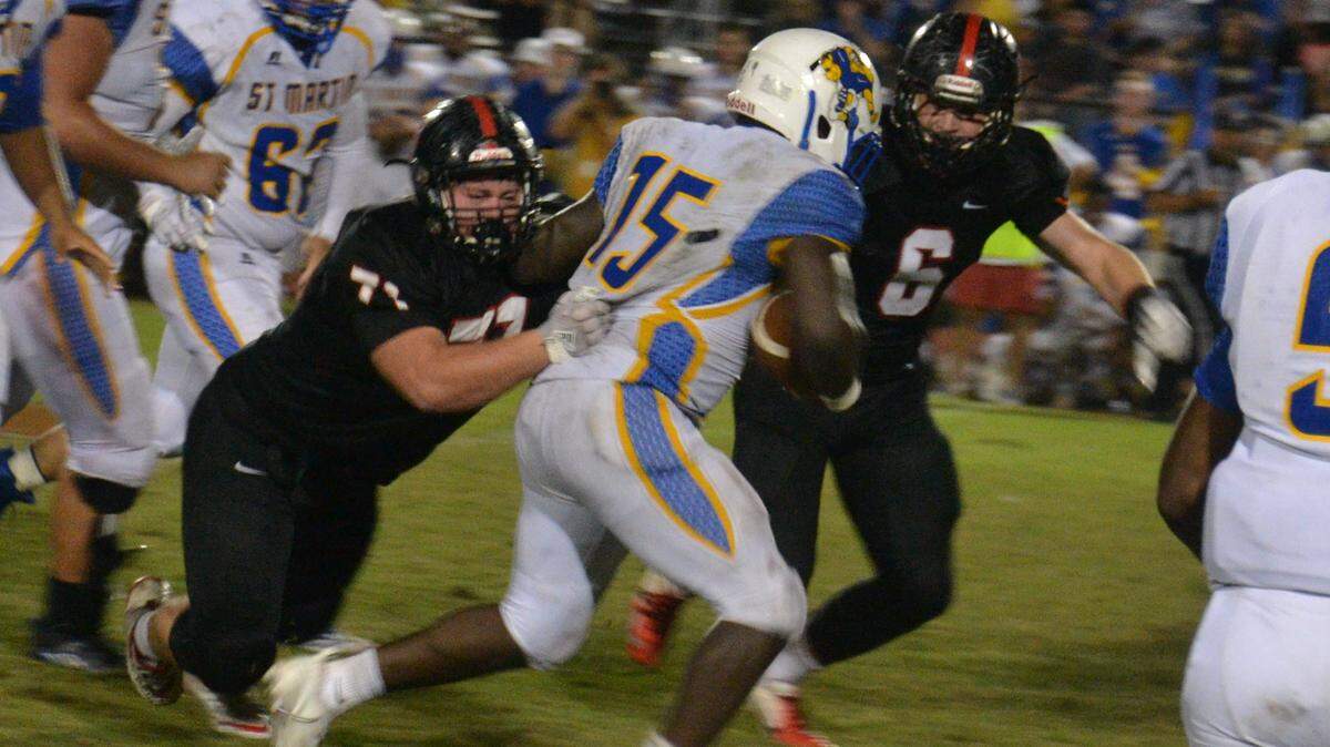 St. Martin running back Jay McGee (15) carries the ball for yardage at St. Stanislaus Friday night.