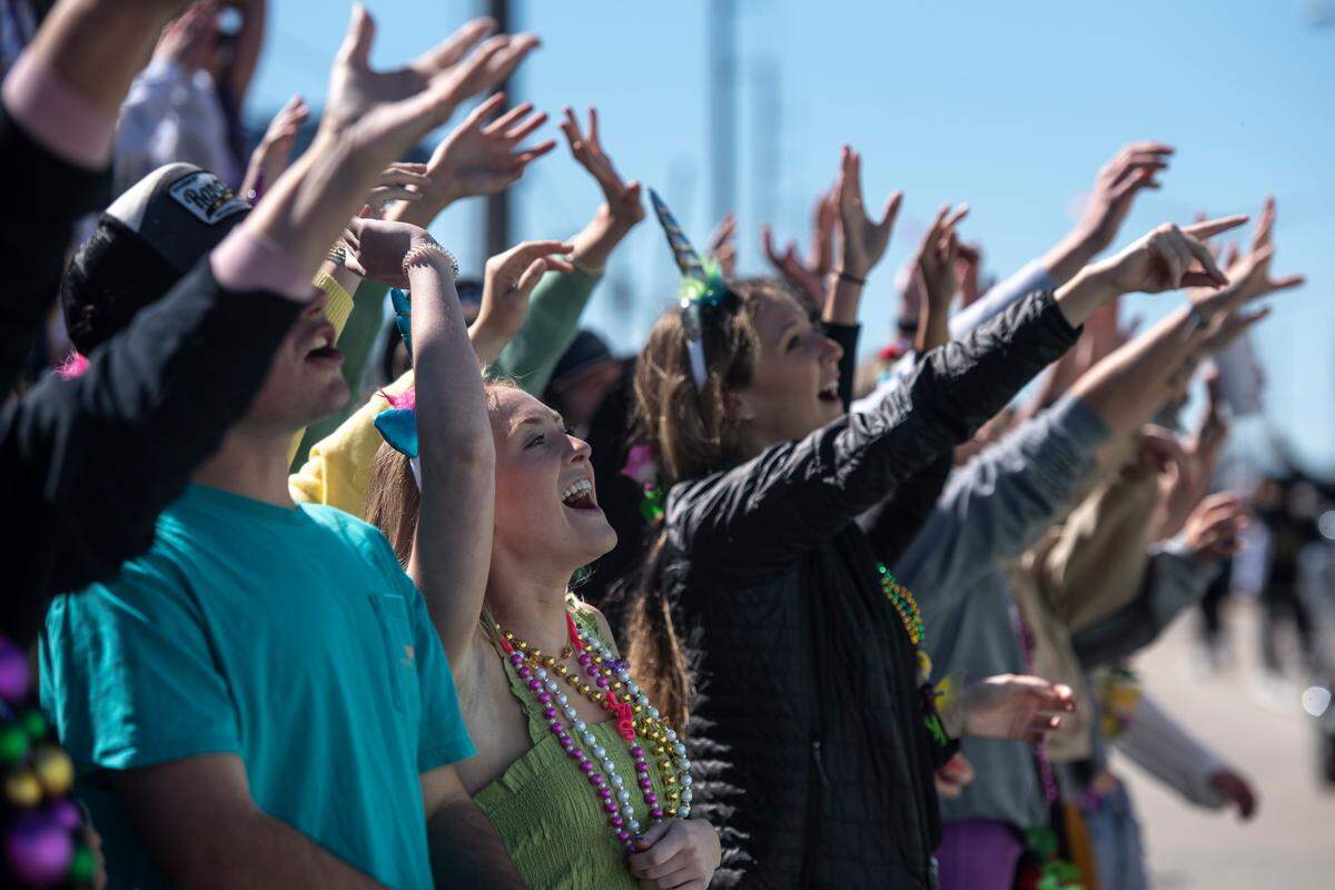 Crowds cheer for beads to be tossed in their direction during the Krewe of Nereids Mardi Gras parade on Highway 90 in Bay St. Louis on Sunday, Feb. 12, 2023.