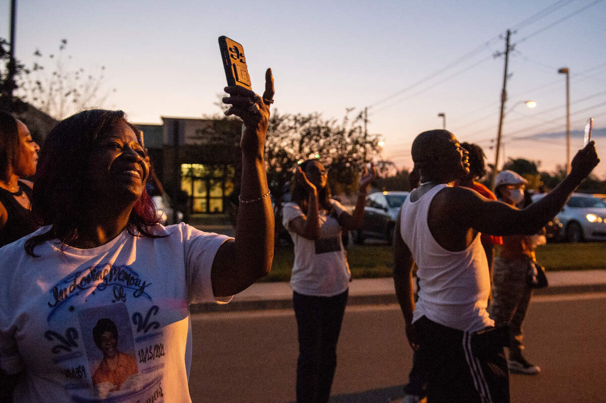 Family and friends watch and take videos as balloons are released into the air in honor of Inez Thomas in East Biloxi on Friday, Oct. 22, 2021.