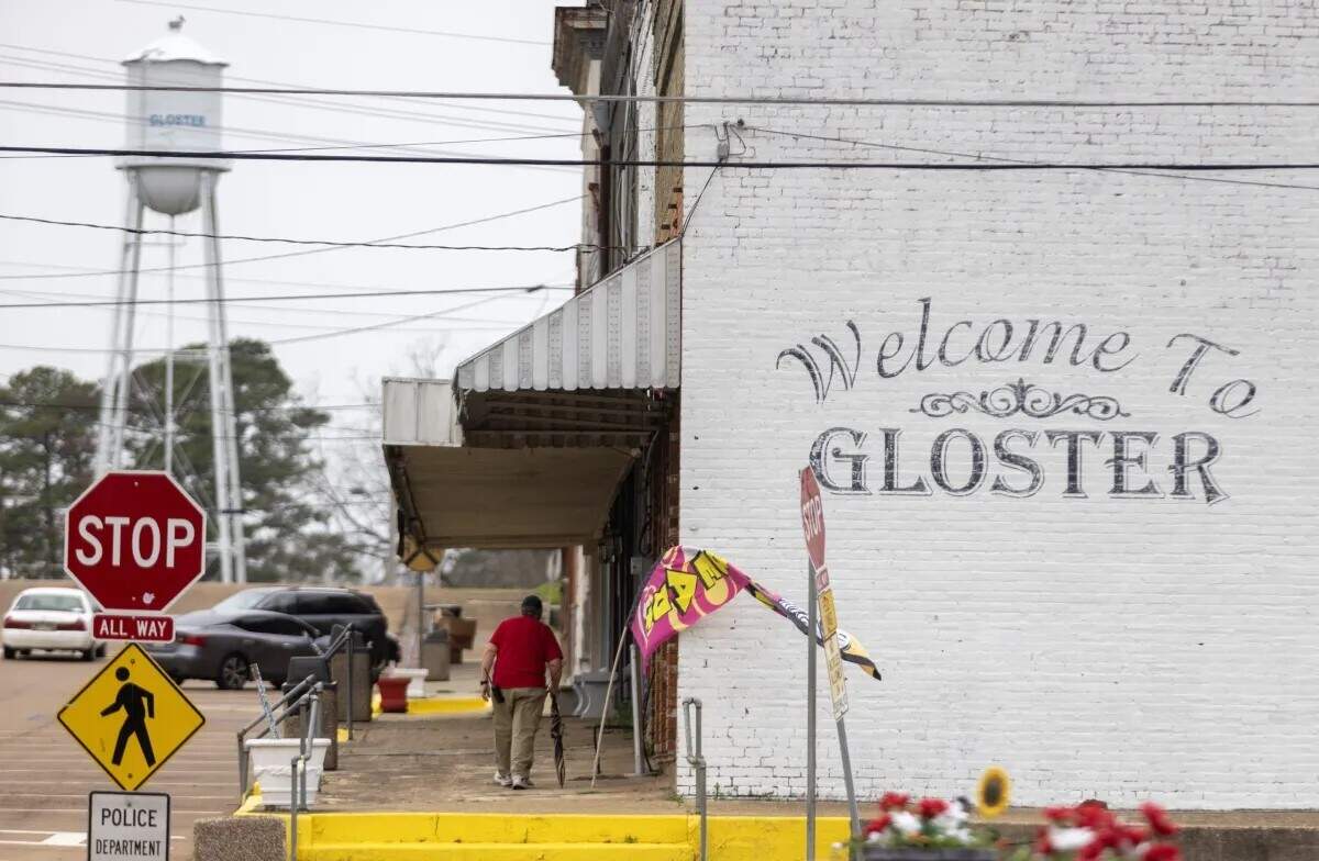 A man walks downtown in Gloster earlier this year. Some residents of the town are upset because of the industrial pollution caused by Drax Group, a U.K.-based energy company that operates a wood pellet production plant in the town.