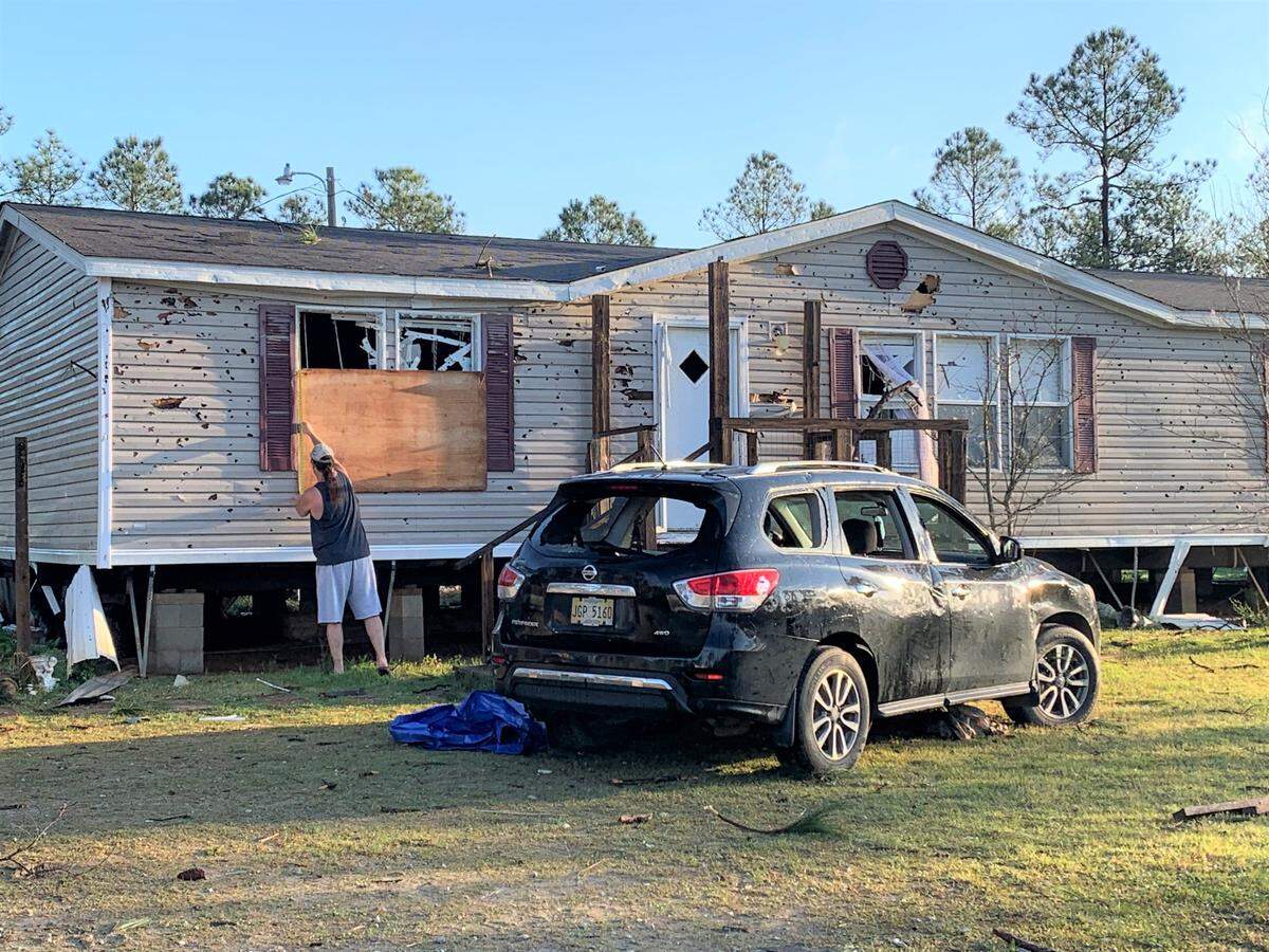 Terry Watson measures a window at his in-law’s house for plywood after a tornado blew out the windows in the home and his wife’s SUV parked out front after a tornado touched down on Fox Ridge Road in Vancleave Wednesday night.
