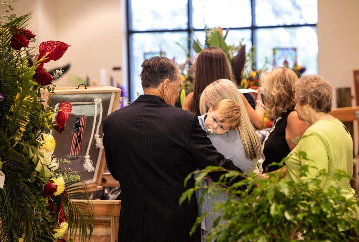 Declan Seal, 2, is held by his mother, Cassie Lassabe, at the funeral service for Declan’s father, Cayce Seal, 28, at St. Clare Catholic Church in Waveland on July 1, 2021.