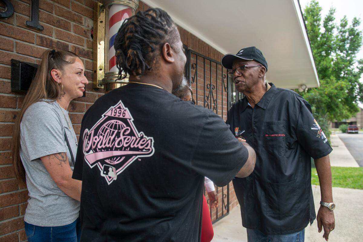 Tyrone Burton greets customers outside his barbershop in Biloxi on Wednesday, May 21, 2025.