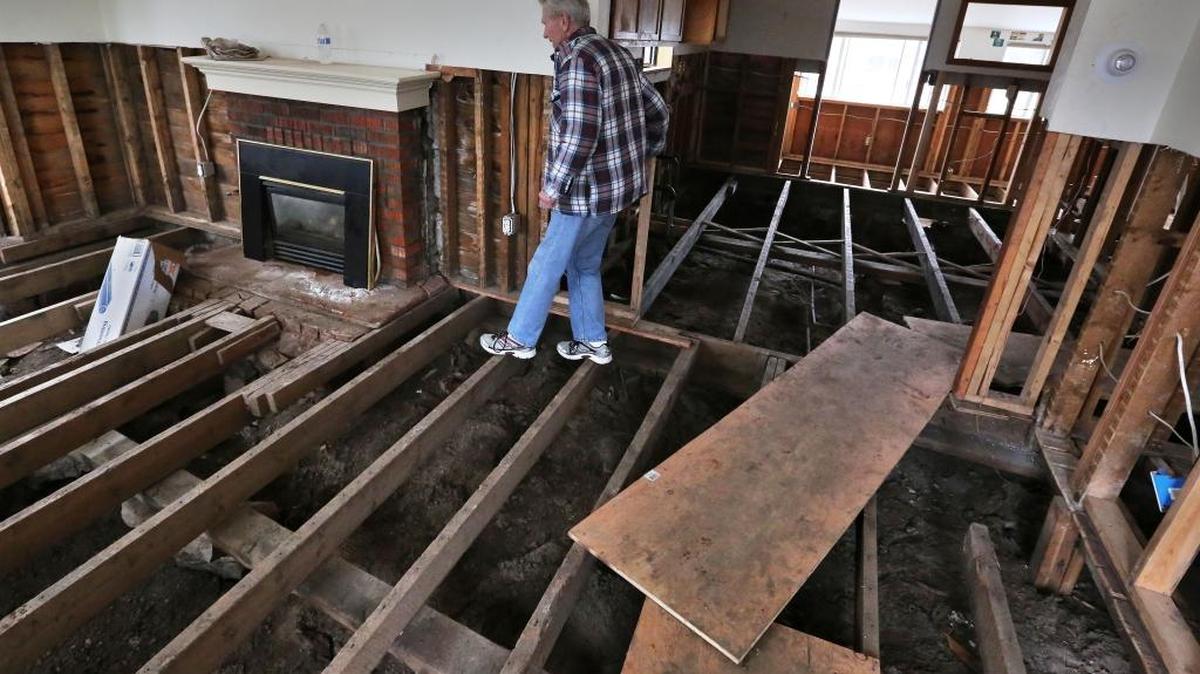 In this March 22, 2014 file photo, a man walks along the naked beams in the remains of his flood-damaged home in Lyons, Colo., destroyed in Sept. 2013. Houston’s population is growing quickly, but when Harvey hit last weekend there were far fewer homes and other properties in the area with flood insurance than just five years ago, according to an Associated Press investigation.