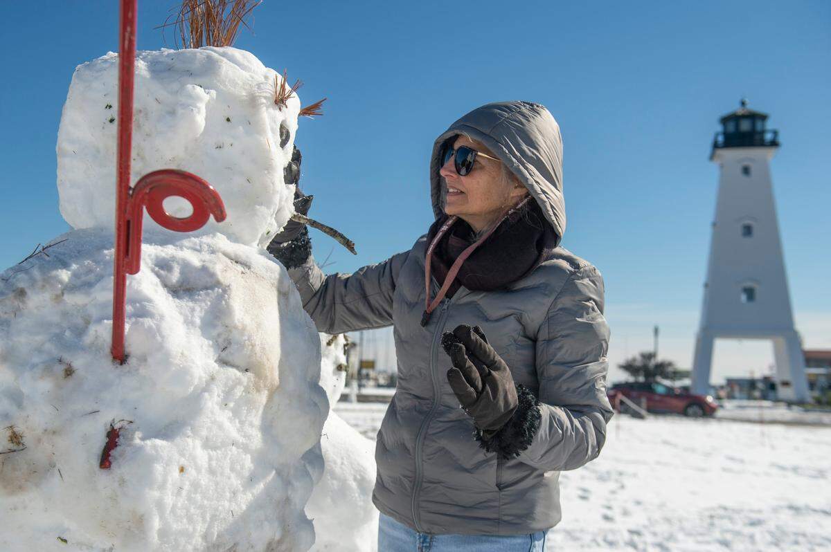 Stephanie Crow puts the finishing touches on a snowman Wednesday, Jan. 22, 2025, in Gulfport.