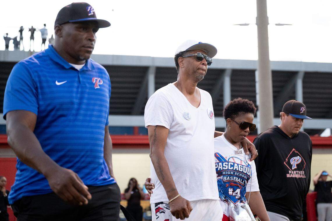 Braylyn Knowles’ parents Carlos, middle left, and Erika, middle right, walk onto the field before Thursday’s game.