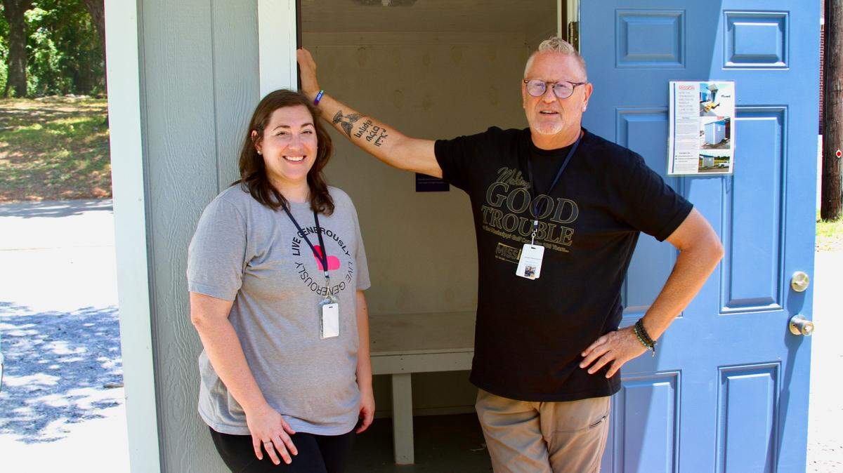 Dhiana Skrmetti and James Pennington of Back Bay Mission in Biloxi stand in the doorway of a mobile tiny house emergency shelter. Back Bay, which serves the homeless population, plans to build 21 of the shelters on trailers for use as temporary housing at the Mercy Cross Center on the grounds of the former Mercy Cross High School. The shelters, which will be heated and cooled, consist of one small room with a wooden platform for a mattress.