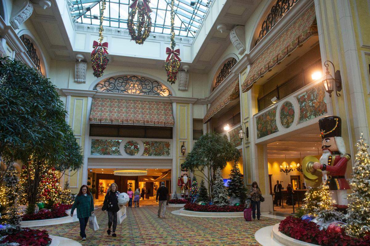 Guests walk through the at the Beau Rivage Casino in Biloxi on Thursday, Dec. 1, 2022 as Christmas decoration hang overhead.