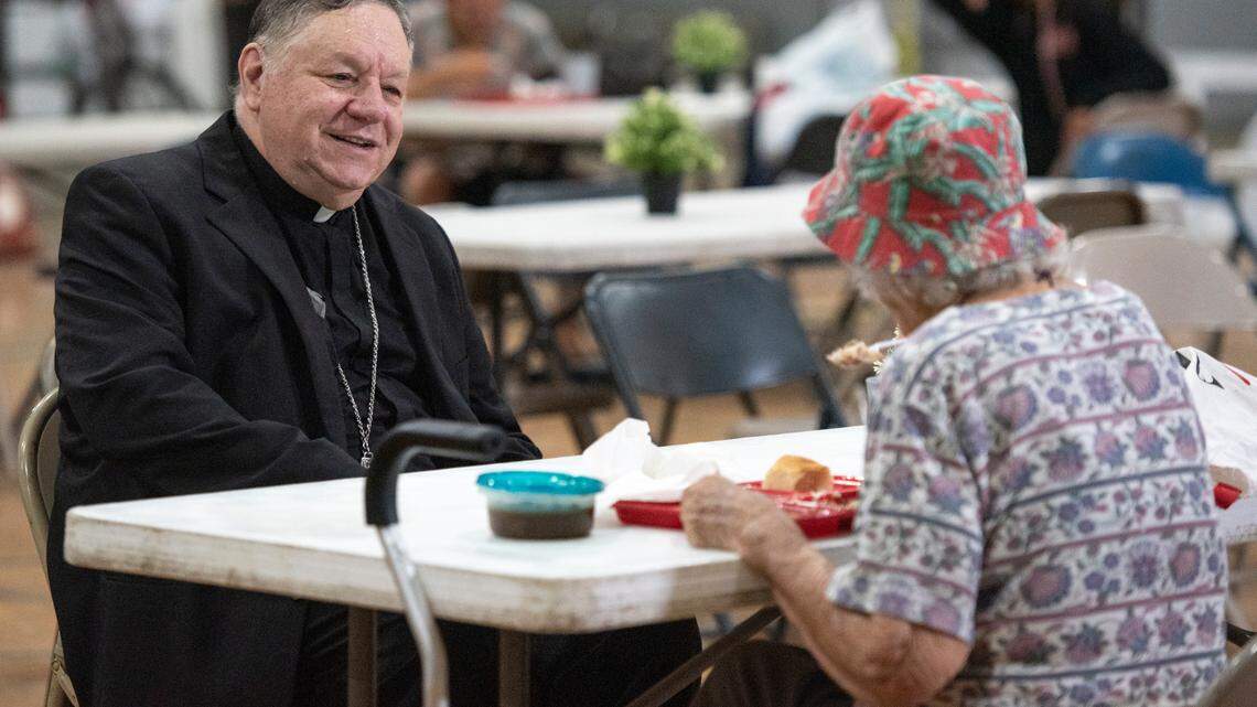 Bishop Louis F. Kihneman III visits with people experiencing homelessness at the former Mercy Cross High School in Biloxi during a lunch provided by Loaves and Fishes on Tuesday, May 14, 2024. Catholic Social Services of South Mississippi is renovating the space as a day center that will provide resources to help individuals find permanent housing.