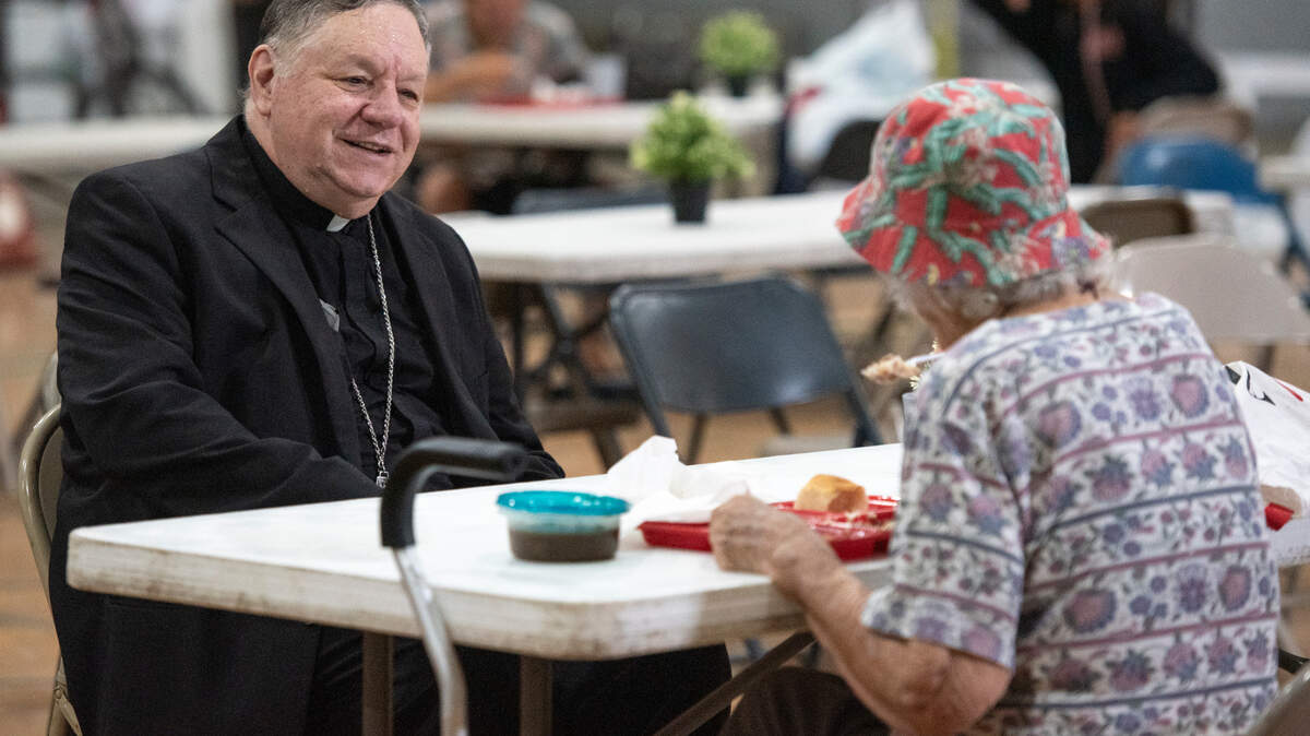 Bishop Louis F. Kihneman III visits with people experiencing homelessness at the former Mercy Cross High School in Biloxi during a lunch provided by Loaves and Fishes on Tuesday, May 14, 2024. Catholic Social Services of South Mississippi is renovating the space as a day center that will provide resources to help individuals find permanent housing.