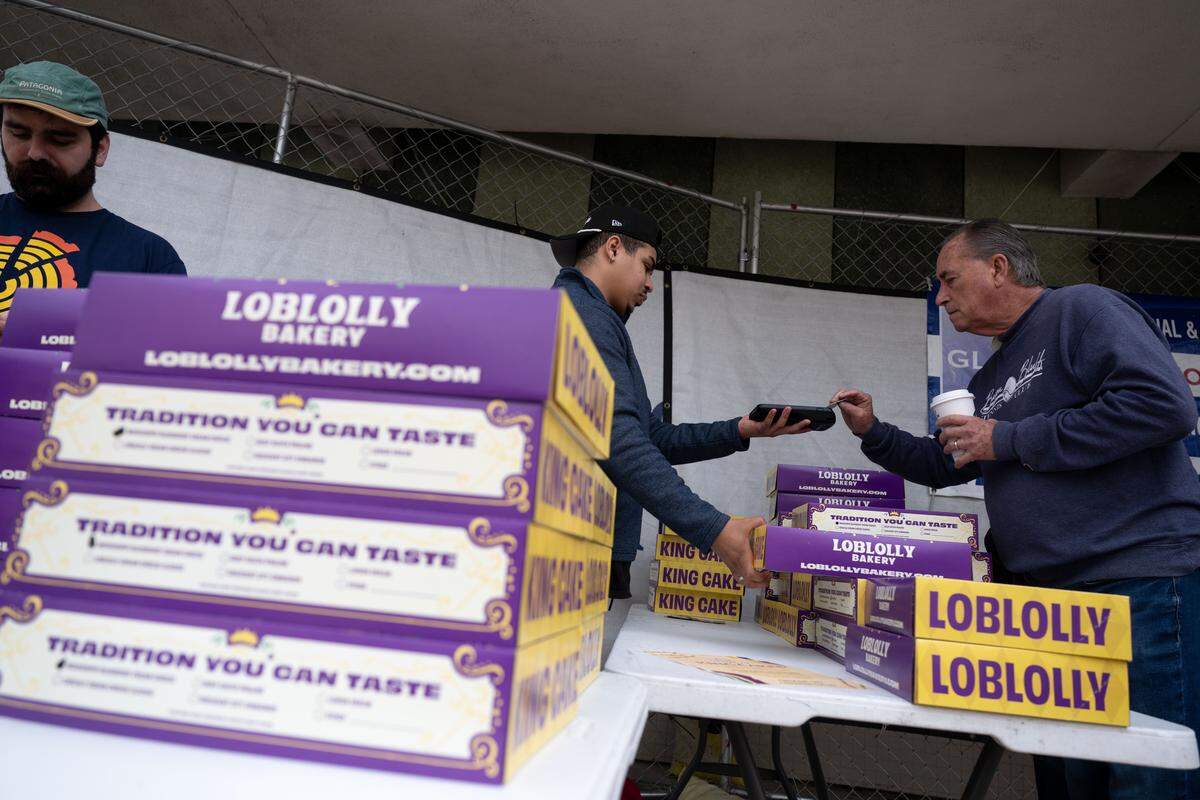 Customers pay for Loblolly Bakery king cakes Wednesday during a pop-up sale hosted by the bakery in Gulfport.