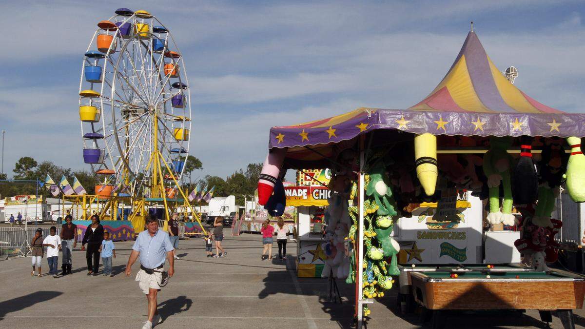 TIM ISBELL/SUN HERALD/FILE 
 Vendors make last minute preparations as patrons arrive at a past Jackson County Fair. The fair starts Sunday.